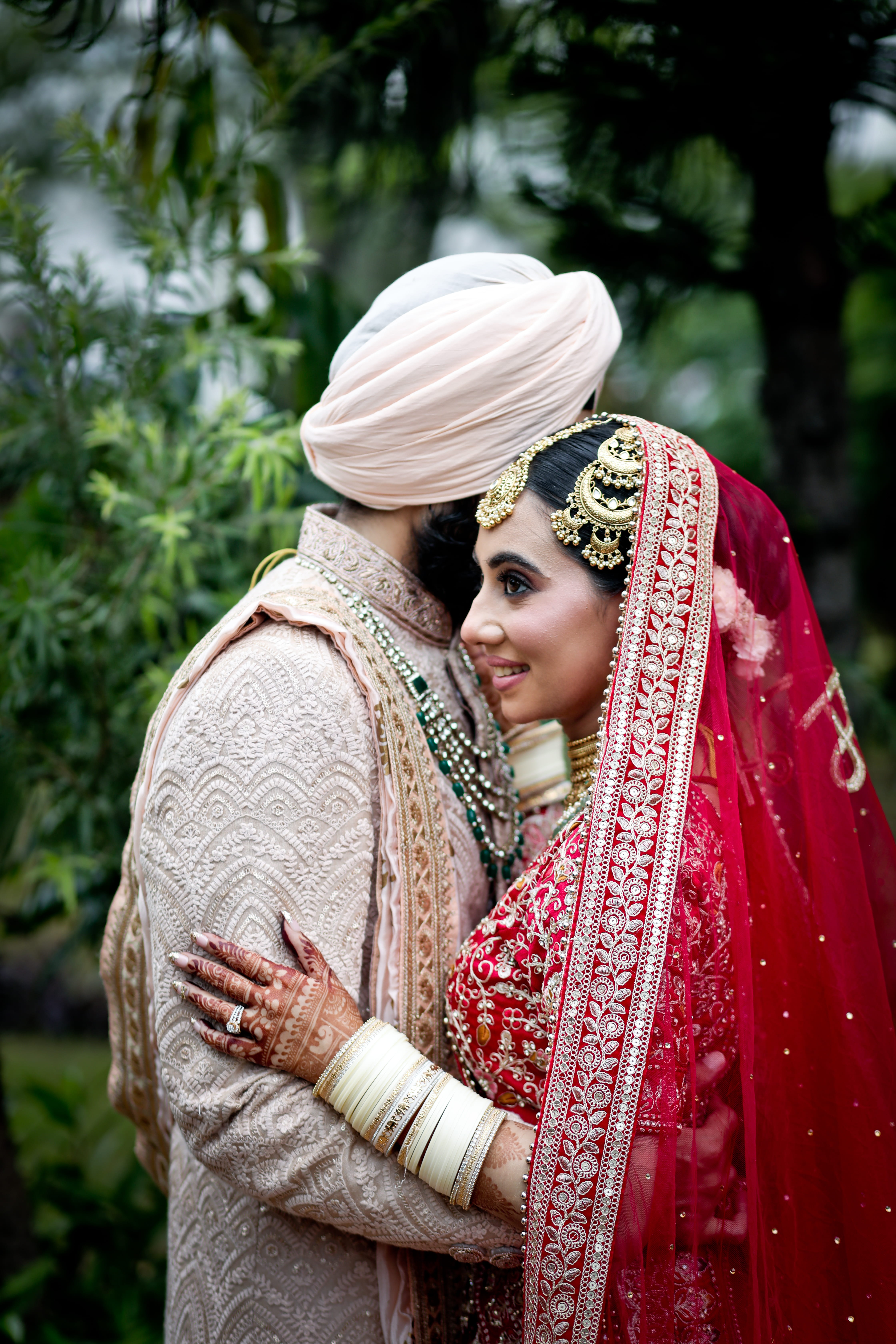 side view of beautiful happy young wedding couple able to kiss in park